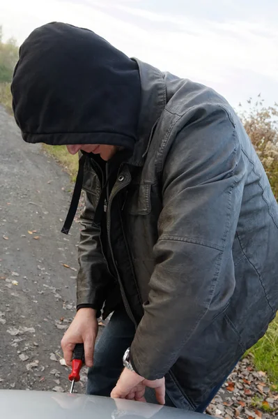 Hooligan breaking into car — Stock Photo, Image