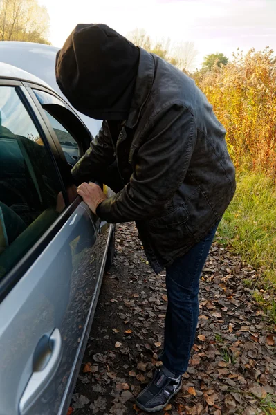 Huligan bryter in i bil — Stockfoto