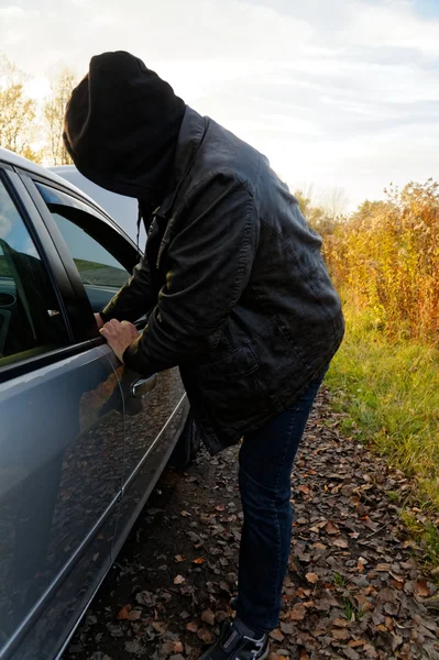 Huligan bryter in i bil — Stockfoto