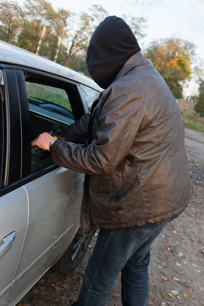 Hooligan breaking into car — Stock Photo, Image