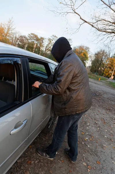 Hooligan breaking into car — Stock Photo, Image