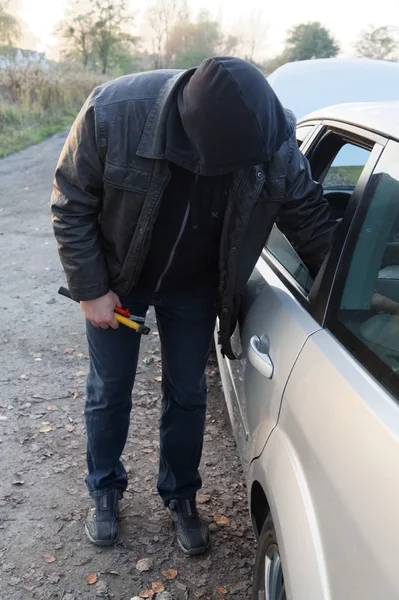 Hooligan breaking into car — Stock Photo, Image