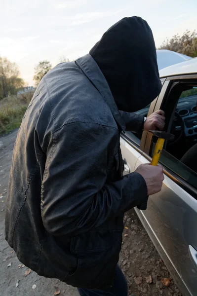 Hooligan breaking into car — Stock Photo, Image