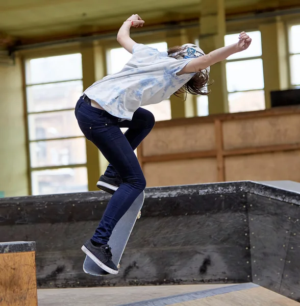 Adolescente pattinatrice salto alto al chiuso — Foto Stock