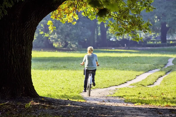 Woman on the bicycle in park — Stock Photo, Image