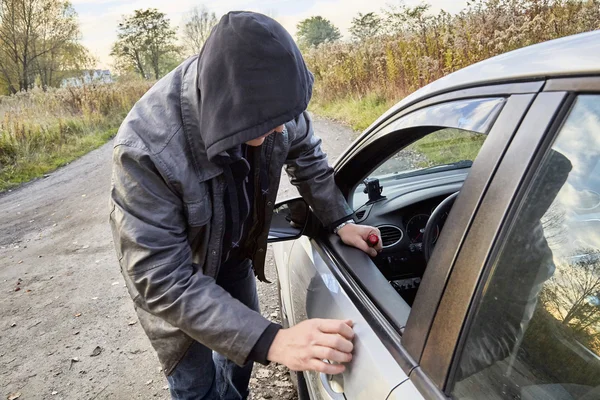 Huligan bryter in i bil — Stockfoto