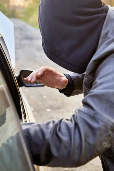 Hooligan breaking into car — Stock Photo, Image