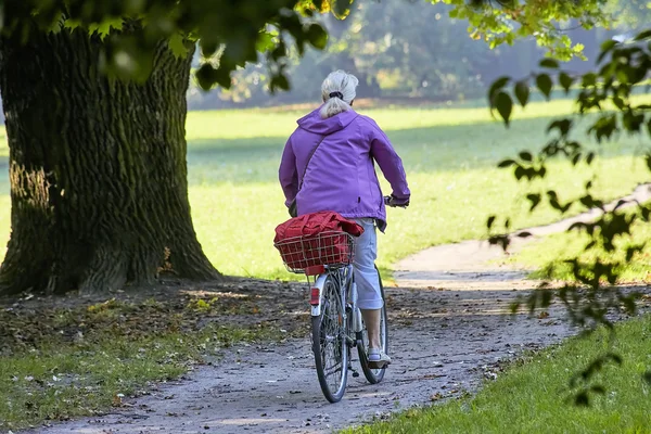 Kvinna på cykel i park — Stockfoto