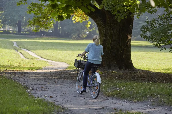 Mujer en bicicleta en el parque — Foto de Stock