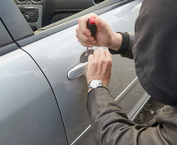 Hooligan breaking into car — Stock Photo, Image