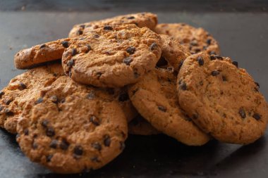 Çiğnenmiş çikolatalı yulaflı kurabiye. Siyah arka planda çikolatalı ev yapımı yulaflı kurabiyeler..