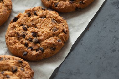 Çıtır yulaf ezmeli kurabiyeler, üzerinde çikolata ve kağıt tepsi. Ev yapımı kekler. Boşluğu kopyala