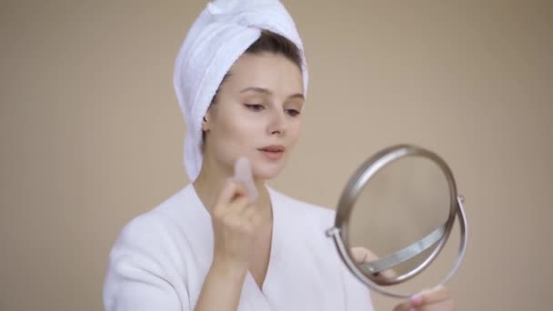 Mulher usando Gua Sha Stone. Jovem bela mulher Gua Sha pedra para drenagem linfática cuidados da pele high-end isolado. Pele verdadeira — Vídeo de Stock