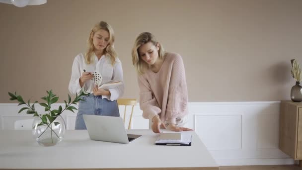 Yaratıcı iş kadınları modern açık planlama ofisinde gayri resmi toplantı yapıyorlar. Dizüstü bilgisayarda çalışan iki genç kadın serbest yazar.. — Stok video