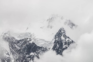 Atmospheric minimalist alpine landscape with massive hanging glacier on snowy mountain peak. Big balcony serac on glacial edge. Low clouds among snowbound mountains. Majestic scenery on high altitude. clipart