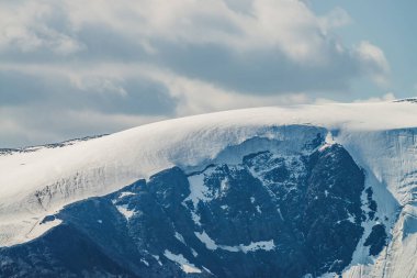 Atmosferik dağ manzaralı buzullu karlı dağ. Tepesi karla kaplı dev dağlı manzaralı dağlık bir arazi. Görkemli doğanın muhteşem manzarası. Yüksek irtifada kar altında büyük bir tepe..