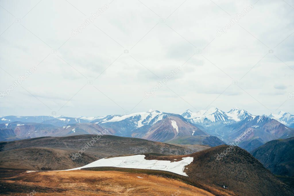 Atmospheric alpine landscape to rocky mountain with glacier. Snowy rockies in highland valley and giant glacial ridge. Snowy mountain range. Flying over mountains. Wonderful scenery on high altitude.