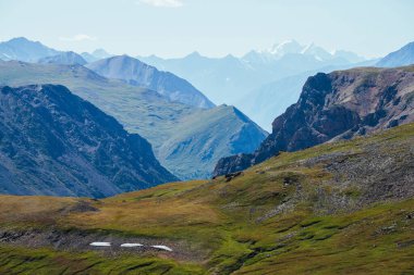 Kayalık dağların ve derin vadilerin arkasındaki karlı dağlarla muhteşem bir dağ manzarası. Dev kayalar ve derin uçurumlar. Devasa buzulları, büyük kayaları ve uçurumları olan harika dağlık arazi manzarası..