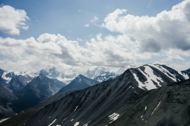 Gri bulutlu gökyüzünün altında kocaman buzul dağları olan muhteşem dramatik alp manzarası. Karlı dağlara ve buzullara harika bir dağ manzarası. Büyük kayalar ve buzullarla atmosfer manzarası.