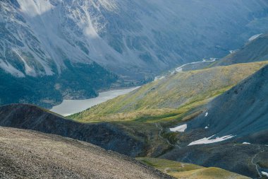 Atmosferik alp manzarası, dağlı gölü olan güzel bir vadi ve doğa desenli dev desenli yamaçlar. Büyük kayalık tepelere ve büyük dağlara muhteşem bir hava manzarası. Dağ yamacındaki orman