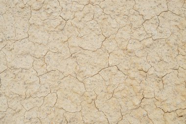 Çatlak kuru toprakların doğa arka planı. Çatallı toprağın doğal dokusu. Kırık kil yüzeyi, çorak çorak araziye yakın çekim. Kurak iklimle dolu bir bölge. Dünyada cansız bir çöl
