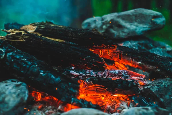 火の近くで焼かれた鮮やかな色付きの薪 キャンプファイアと青煙のオレンジの炎と大気暖かい背景 たき火の想像を絶するフルフレームイメージ 美しい火災でログを燃焼 — ストック写真