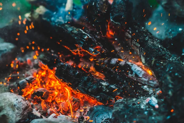 火の近くで焼かれた鮮やかな色付きの薪 キャンプファイアのオレンジ色の炎で大気中の背景 たき火のフルフレームイメージ 輝くメンバーと空気中の灰の暖かい旋風 Bokehにスパーク — ストック写真