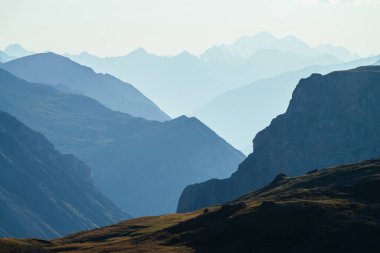 Derin vadinin arkasındaki büyük dağların muhteşem manzarası. Devasa kayalıkları ve derin uçurumları olan harika dağ manzarası. Uçurumu olan bir dağ manzarası. Büyük kayalar ve uçurumlar.