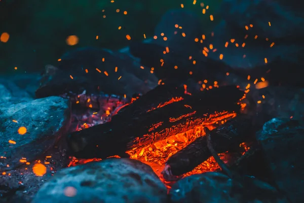 火の近くで焼かれた鮮やかな色付きの薪 キャンプファイアのオレンジ色の炎で大気中の背景 たき火の想像を絶するフルフレームイメージ 空気中のメンバーを育てる 暖かい丸太 明るい火花Bokeh — ストック写真