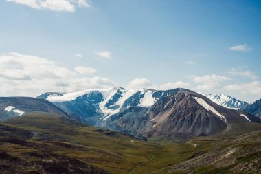 Büyük dağ sıraları ve buzulları olan manzaralı bir yer. Devasa dağ sırtının tepesinde kar. Güneşli bir günde güzel, büyük, karlı dağlar. Geçitten karlı zirveye ve gün ışığında buzullu tepelere.