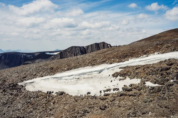 岩場の丘の上に氷河と大気中の山の風景 太陽の下で雪と石のパスを持つ素晴らしい景色 山の高高度で石の 雪のパスです 高原の自然への美しい景色 — ストック写真