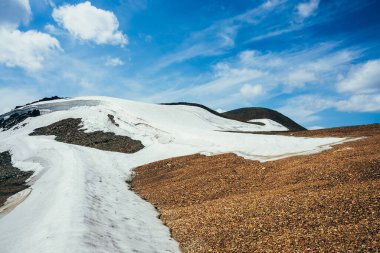 Bulutlu gökyüzünün altındaki Stony Hill 'de buzla kaplı güzel bir buzul. Dağda kar. Kayanın üstünde ateş. Yüksek irtifada atmosferik alp manzarası. Görkemli doğanın harika dağlık arazisi..