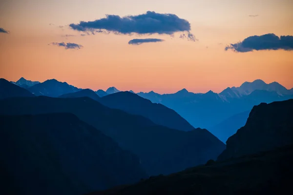 美しい山々のシルエットと青い雲と黄金のグラデーションの空とカラフルな夜明けの風景 絵のように多色の夕日と鮮やかな山の風景 山の範囲への風景日の出ビュー — ストック写真