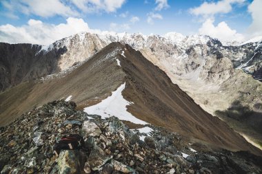 Atmosferik minimalist dağ manzarası ve muazzam karlı dağ sıraları. Combe Rocky Hill 'de kar ya da ateş. Mavi gökyüzü karlı tepenin üzerinde. Kaya akıntısı. Yüksek irtifada görkemli manzara.