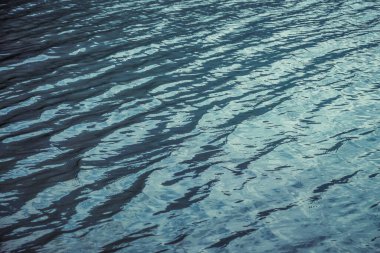 Mor, sakin dağ gölü suyu dokusu. Su yüzeyinde meditasyon dalgalanmaları. Violet Gölü 'nün doğası çok az. Açık mavi suyun doğal arkaplanı. Göl parçasının tam çerçevesi.