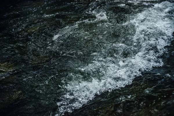 急流と山の川の暗い水の流れの自然背景 海のサーフィンの完全なフレーム 海の波の自然なテクスチャの背景 潮のクローズアップのテクスチャ 渓流の暗い水面 — ストック写真