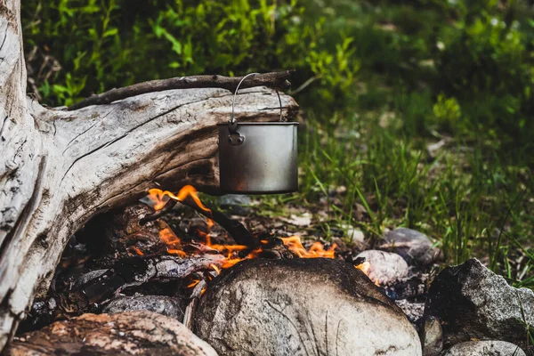 ケトルが火事になった 野火で料理をする 美しい大きなログのたき火のクローズアップで燃焼します 野生の自然の中で生き残る コルドロンとの素晴らしい炎 鍋が炎にかかっている キャンプファイアの背景 — ストック写真