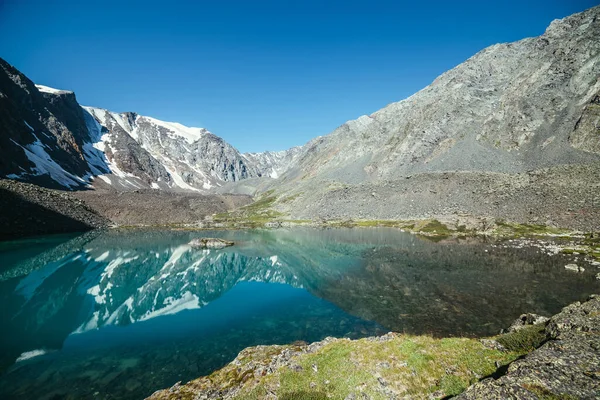 눈덮인 호수에 반사되어 반사되는 아름다운 햇볕이 내리는 산속의 호수에 반사되어 — 스톡 사진