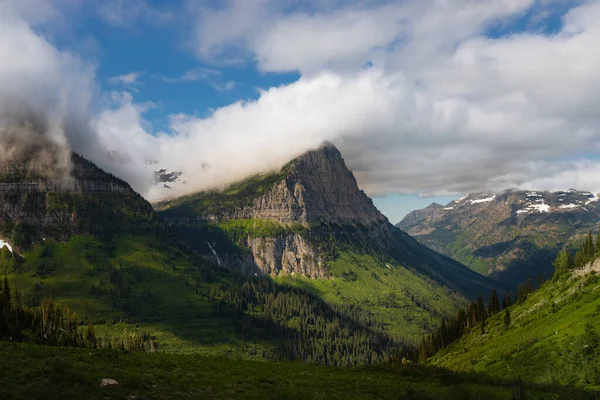 これはモンタナ州の氷河国立公園の山と雲の写真です — ストック写真