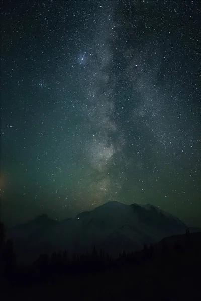 This is a picture of Mount Rainier with milky way in the middle at night in Washington.