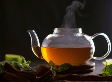 Yeşil yapraklı çaydanlık, çay seremonisi, şeffaf bir fincanda yeşil çay.