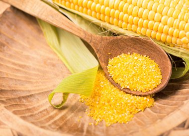 Beyaz arka planda yeşil yapraklı çiğ mısır.