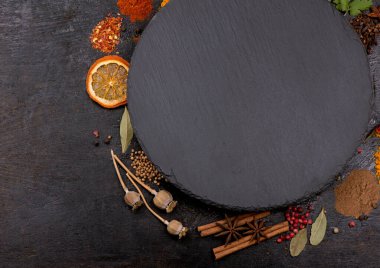 Siyah arka planda yemek pişirmek için baharatlar ve baharatlar..
