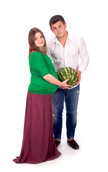 Een man en een zwangere vrouw houden een grote watermeloen in hun handen. geïsoleerd op witte achtergrond — Stockfoto