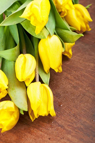 Tulipas amarelas em uma madeira — Fotografia de Stock