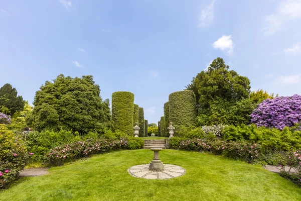 Jardín ajardinado con un viejo reloj de sol . —  Fotos de Stock