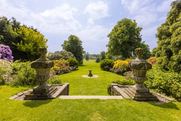 Paisaje con reloj de sol y esculturas de jardín . — Foto de Stock