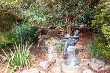 SYDNEY, AUSTRALYA - 1 Nisan 2019: The Satyr, Sydney şehir merkezindeki Royal Botanic Gardens 'da bulunan Frank' Guy 'Lynch' in bronz heykeli.