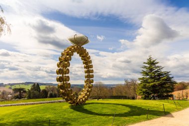 WAKEFIELD, YORKSHIRE, İngiltere - 13 Nisan 2021: Joana Vasconcelos 'un 2018 tarihli modern sanat eseri Solitrio Solitaire ile Yorkshire Heykel Parkı' nda manzara.