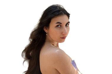 Genç esmer kadın doğrudan seyirciye bakıyor. Çıplak omzunun üzerinden, uzun saçları akıyor. Kolay izolasyon için beyaz arkaplan